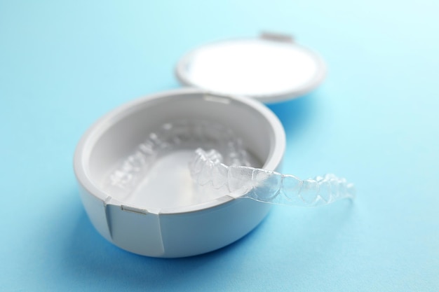 Un cepillo de dientes blanco con una tapa de plástico transparente se asienta sobre un fondo azul.