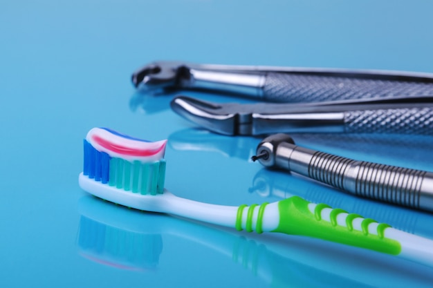 Cepillo de dientes de cuidado dental con herramientas de dentista sobre fondo de espejo