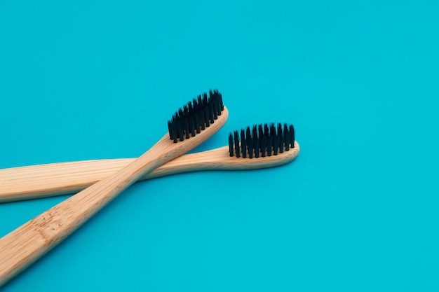 Cepillo de dientes de madera sobre fondo azul.