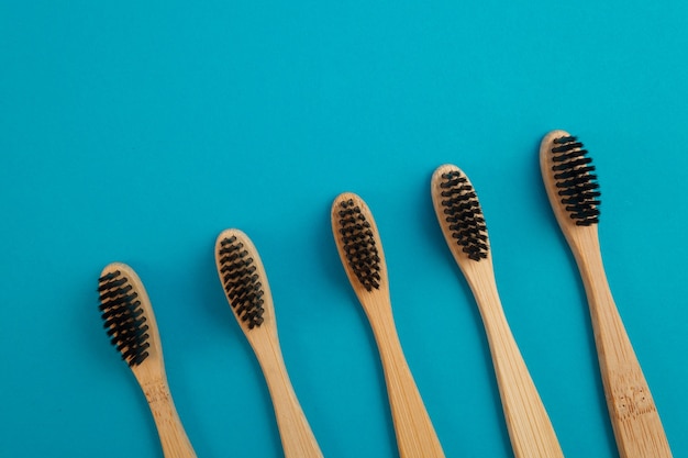 Cepillo de dientes de madera sobre fondo azul.