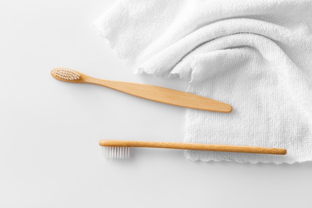 Foto cepillo de dientes de madera con tela blanca sobre un fondo blanco