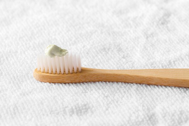 cepillo de dientes de madera con tela blanca sobre un fondo blanco