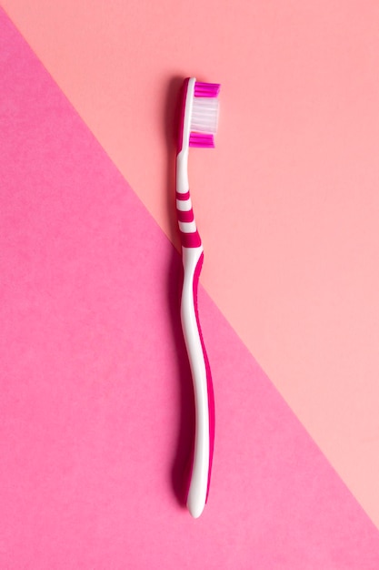 Foto cepillo de dientes rosa sobre fondo rosa