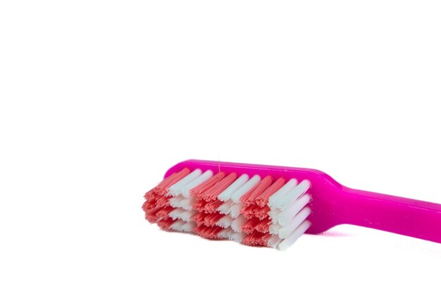 Cepillo de dientes rosado sobre fondo blanco