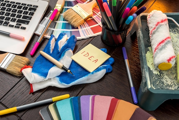 Cepillo y guantes para computadora portátil y paleta de colores para su hogar de diseño en la oficina. Herramientas para la renovación