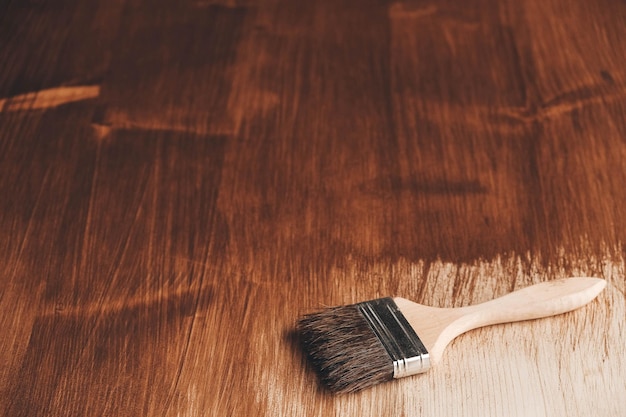 Cepillo con mango de madera y cerdas naturales sobre el fondo de tablones de madera pintados de marrón