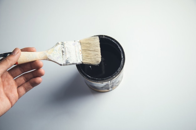 Foto cepillo de mano de hombre sobre la pintura en blanco