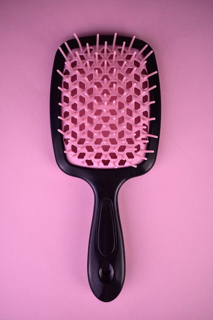 Cepillo de masaje, cepillo para el cabello sobre un fondo rosa.Primer plano.