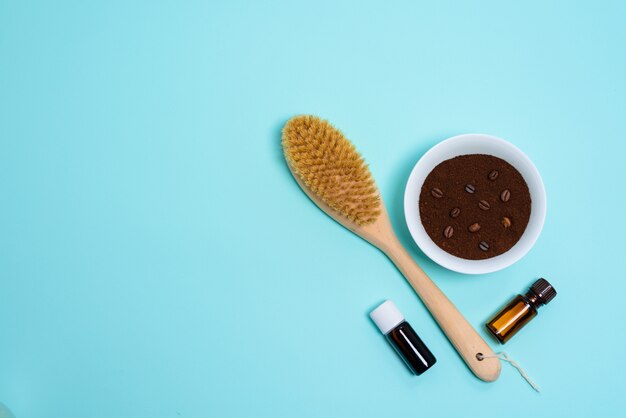 Foto cepillo de masaje corporal anticelulítico seco, aceite de aromaterapia, masajeador y exfoliante de café en azul