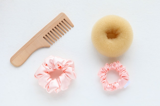 Cepillo para el pelo de madera y scrunchy rosa de seda aislado en el pelo blanco scrunchies bandas elásticas