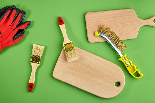 Foto cepillo de pinceles para cepillar productos de madera de madera y guantes de trabajo sobre un fondo verde