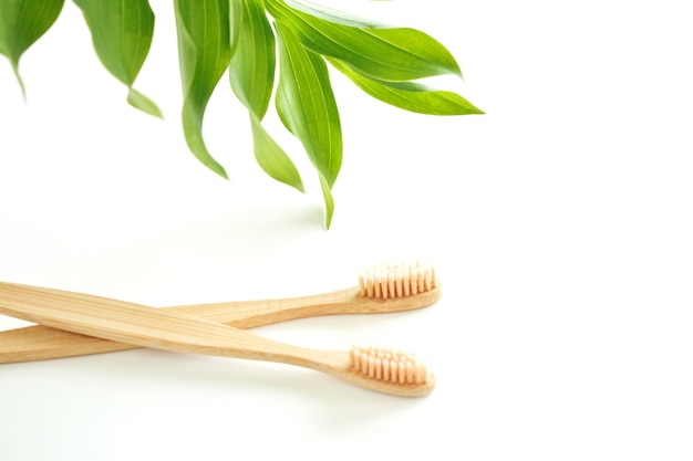 Los cepillos de dientes de bambú son ecológicos con una copia del espacio sobre un fondo blanco. Cero desperdicio. Plástico gratis. Vista superior.