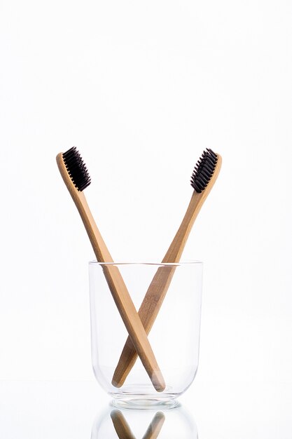 Cepillos de dientes ecológicos de madera en un vaso de vidrio