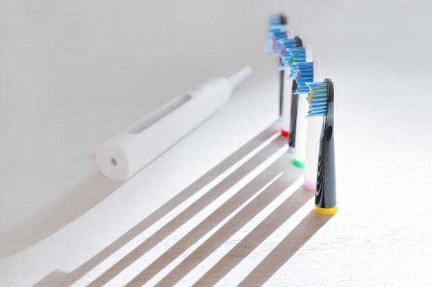 Foto cepillos de dientes eléctricos en día soleado sobre fondo blanco.