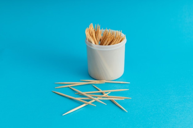 Cepillos de dientes en un frasco sobre un fondo azul.