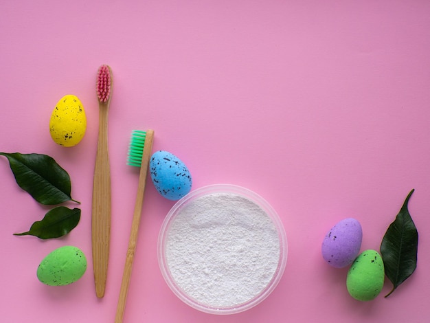 Cepillos de dientes de madera con decoraciones de Pascua sobre fondo rosa