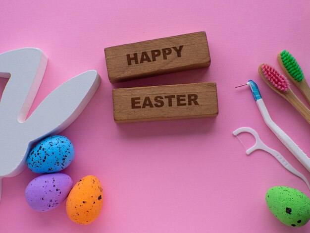 Los cepillos de dientes de madera con decoraciones de Pascua sobre un fondo rosado