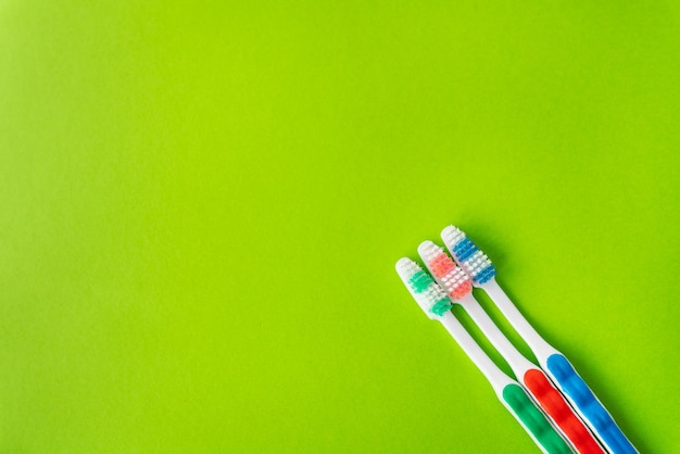 Cepillos de dientes multicolores sobre un fondo verde el concepto de higiene y cuidado dental Lugar para una inscripción