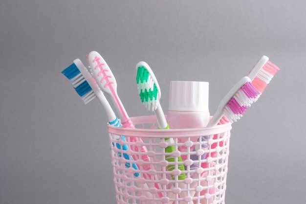 Cepillos de dientes multicolores en un vaso de plástico