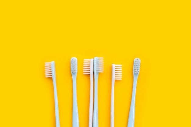 Cepillos de dientes sobre fondo amarillo. Vista superior
