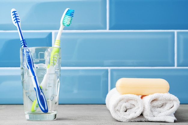 Los cepillos de dientes en un vaso en el baño azul