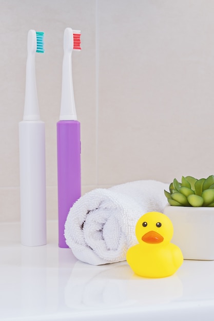 Cepillos eléctricos en lavabo en el baño.