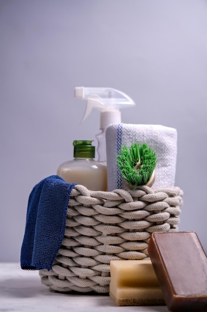 Cepillos, esponjas, guantes de goma y productos de limpieza naturales en la cesta. Productos de limpieza ecológicos.