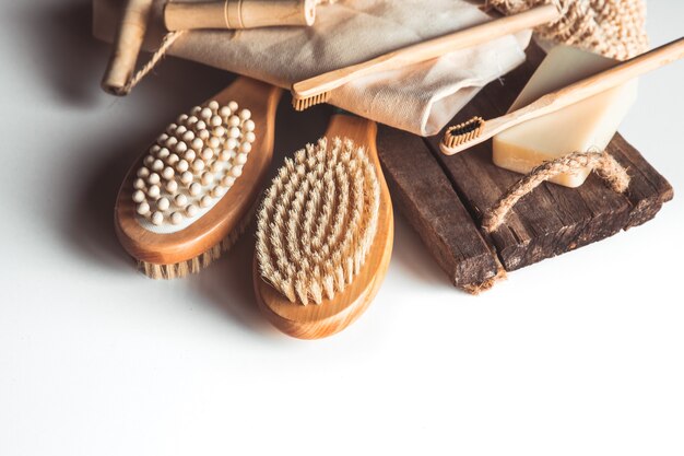 Cepillos naturales de madera y jabón sobre el fondo de hormigón, cepillos de dientes de bambú y cepillo para el cuerpo, jabón artesanal con lufa