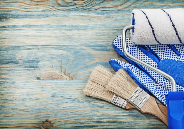 Foto cepillos de rodillos para pintar guantes de seguridad en el concepto de construcción de tableros de madera