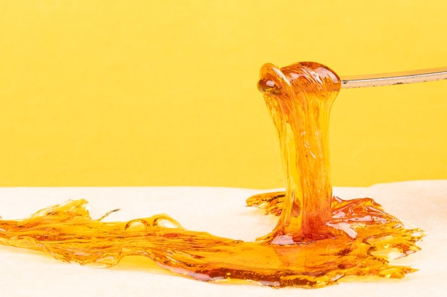 Foto cera concentrada de cannabis de color amarillo anaranjado de cerca, resina de alto contenido de thc dab.