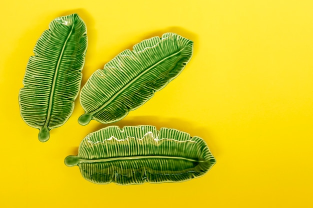 Cerâmica em forma de folha verde sobre fundo amarelo