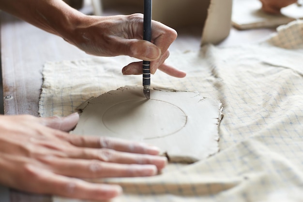 Ceramista feminina trabalhando no estúdio de cerâmica mãos do ceramist dirty of clay processo de criação de cerâmica mestre ceramista trabalha em seu estúdio