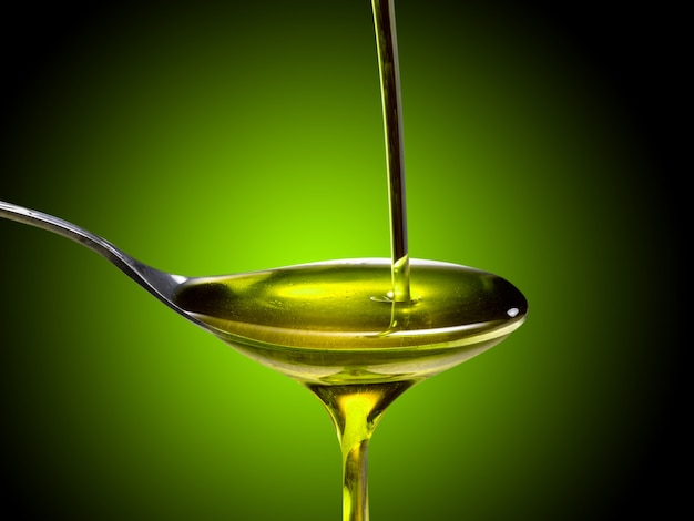 Cerca de aceite de oliva vertido en una cuchara