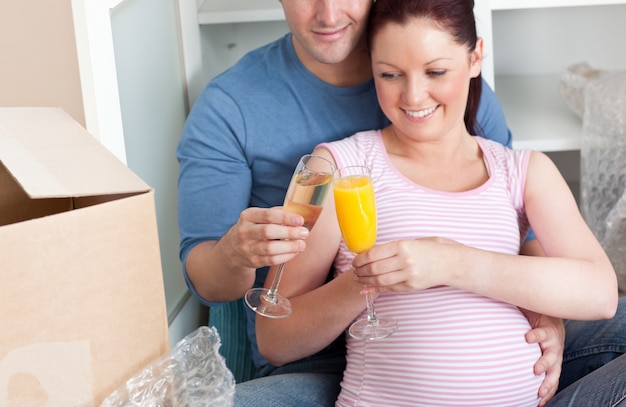 Cerca de una adorable pareja celebrando el embarazo y la eliminación con champán