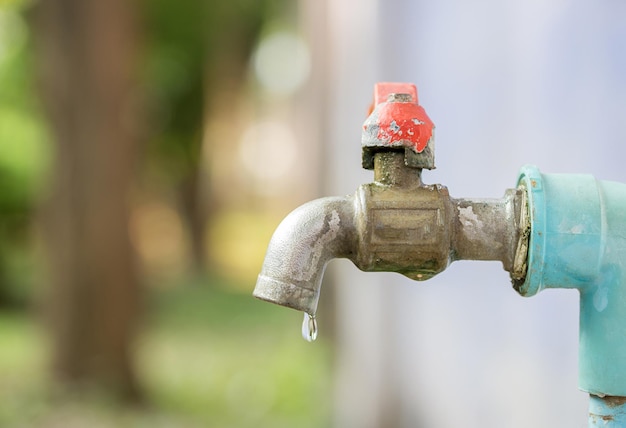 Cerca del agua del grifo en el jardín con fondo borroso