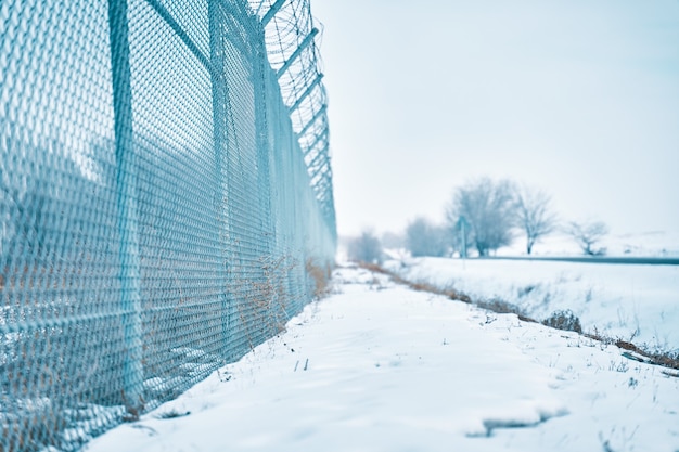Cerca de alambre de púas en la frontera en invierno objeto privado asegurado cerca de la autopista detención de máxima seguridad ...