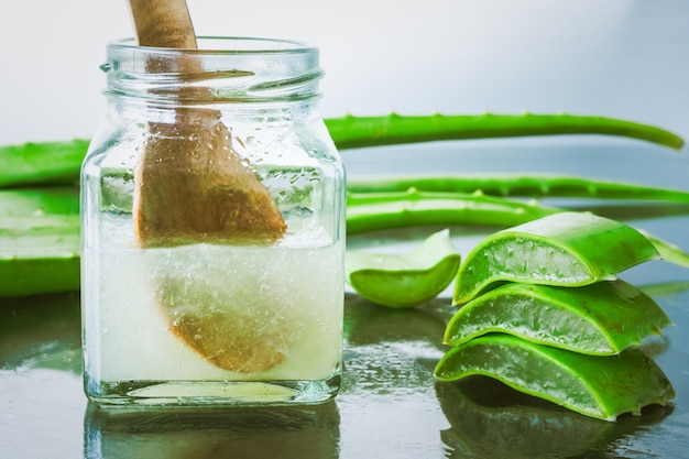 Foto cerca de aloe vera fresca y jalea en botella de vidrio