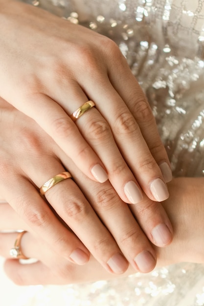 Cerca de los anillos de boda en manos de los recién casados. Manos de los novios