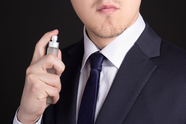 Cerca de apuesto joven hombre de negocios con perfume