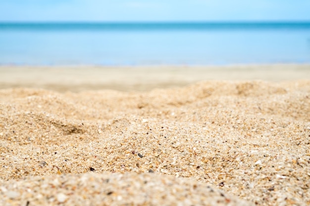 Foto cerca de la arena de la playa con el mar de desenfoque en el fondo