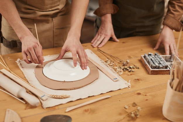 Cerca del artesano masculino irreconocible haciendo cerámica en el taller de alfarería, espacio de copia