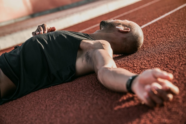 Cerca de un atleta cansado que se relaja después de correr