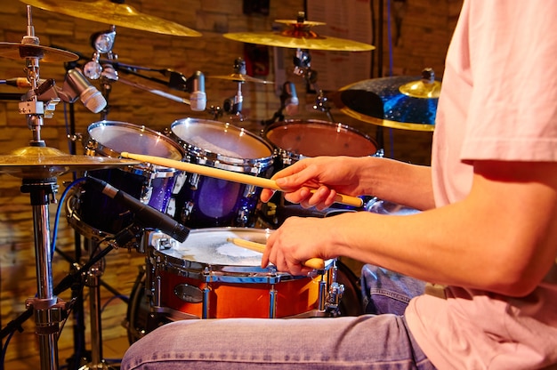 Cerca del baterista tocando el kit de batería en Studio