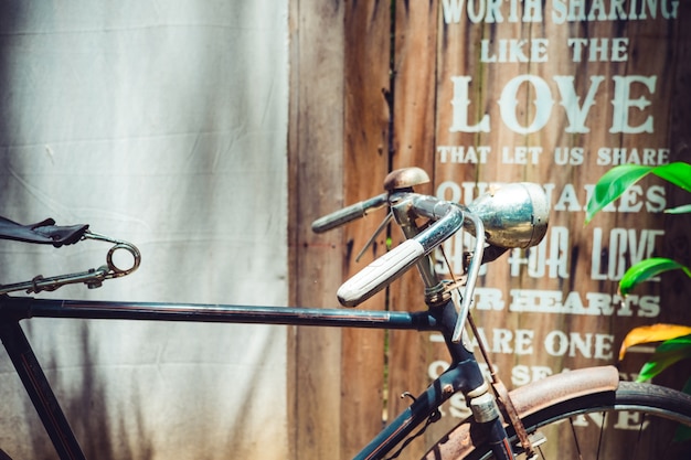 Foto cerca de la bicicleta de época con la pared de arte de madera