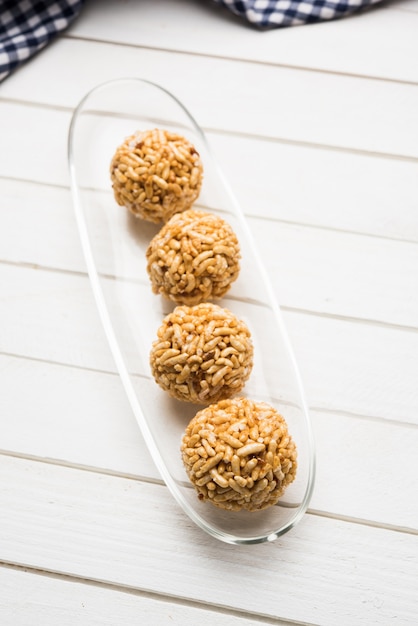 Cerca de bolas de arroz inflado con caramelo o murmura laddu o ladoo, dieta india saludable. enfoque selectivo