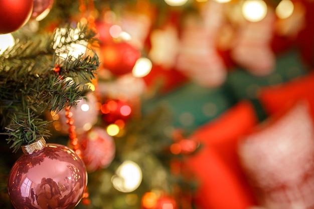 Cerca de bolas en guirnaldas de bokeh de árbol de navidad en el concepto de año nuevo de fondo