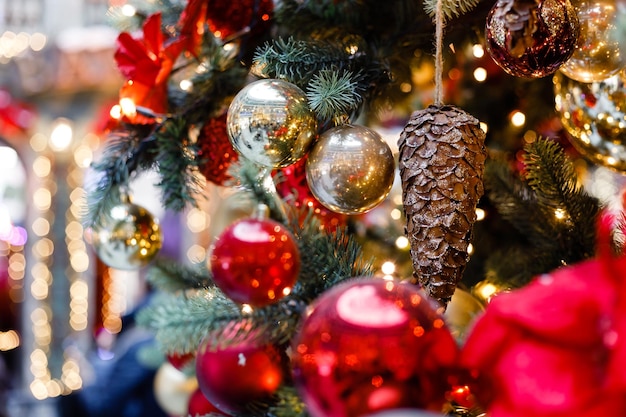 Cerca de bolas en guirnaldas de bokeh de árbol de navidad en el concepto de año nuevo de fondo