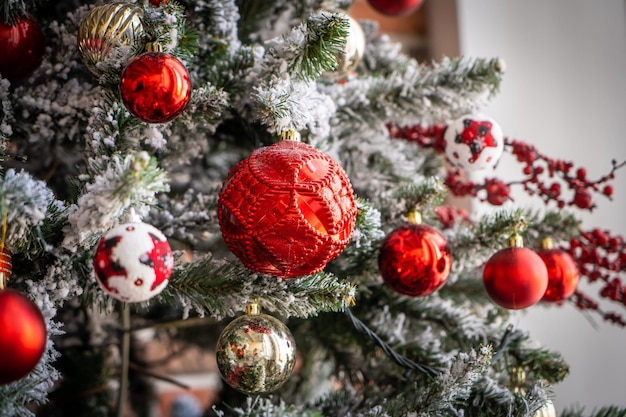 Cerca de bolas rojas y doradas en el árbol de Navidad. Guirnaldas de bokeh en el fondo. Concepto de año nuevo.