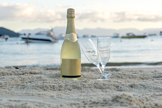 Cerca de una botella de champán en la playa