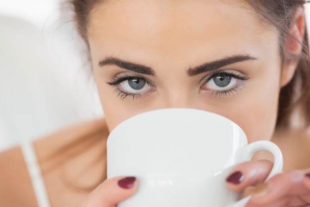 Cerca de un café de consumición lindo de la mujer morena